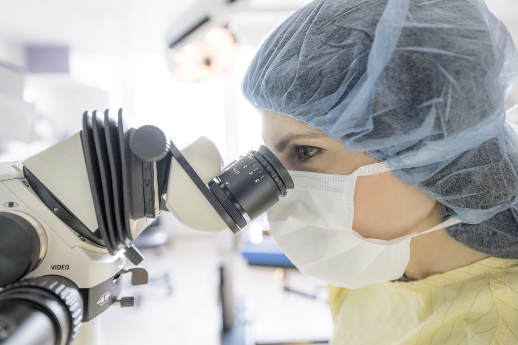 Calgary - Canadian Surgery Solutions - Nurse Looking into a Microscope
